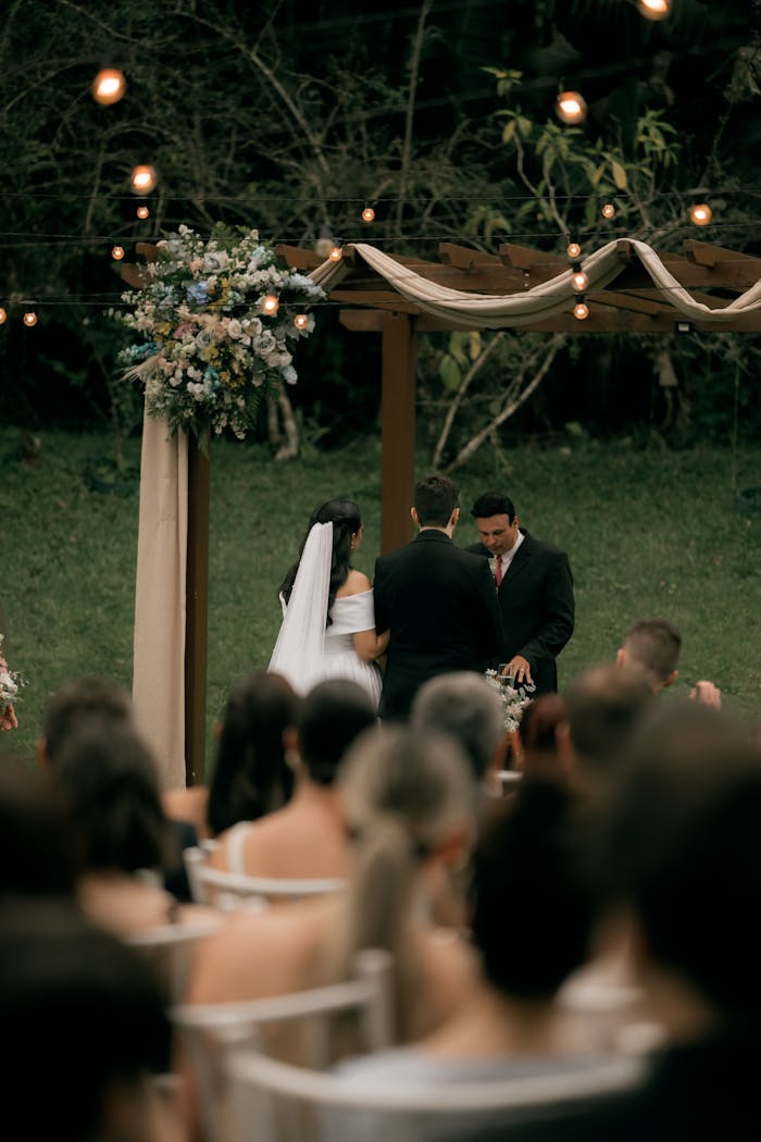 Elegant outdoor wedding ceremony under floral arch, capturing romance and celebration.